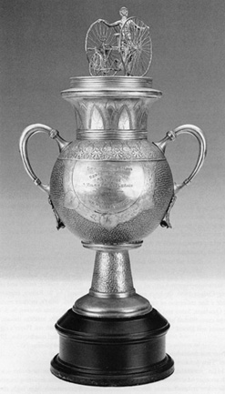 Tricycle Cup Trophy<br>
First Prize, September 9, 1885<br>
Springfield, Massachusetts<br>
Height: 23"<br>
Silver plated<br>
United States